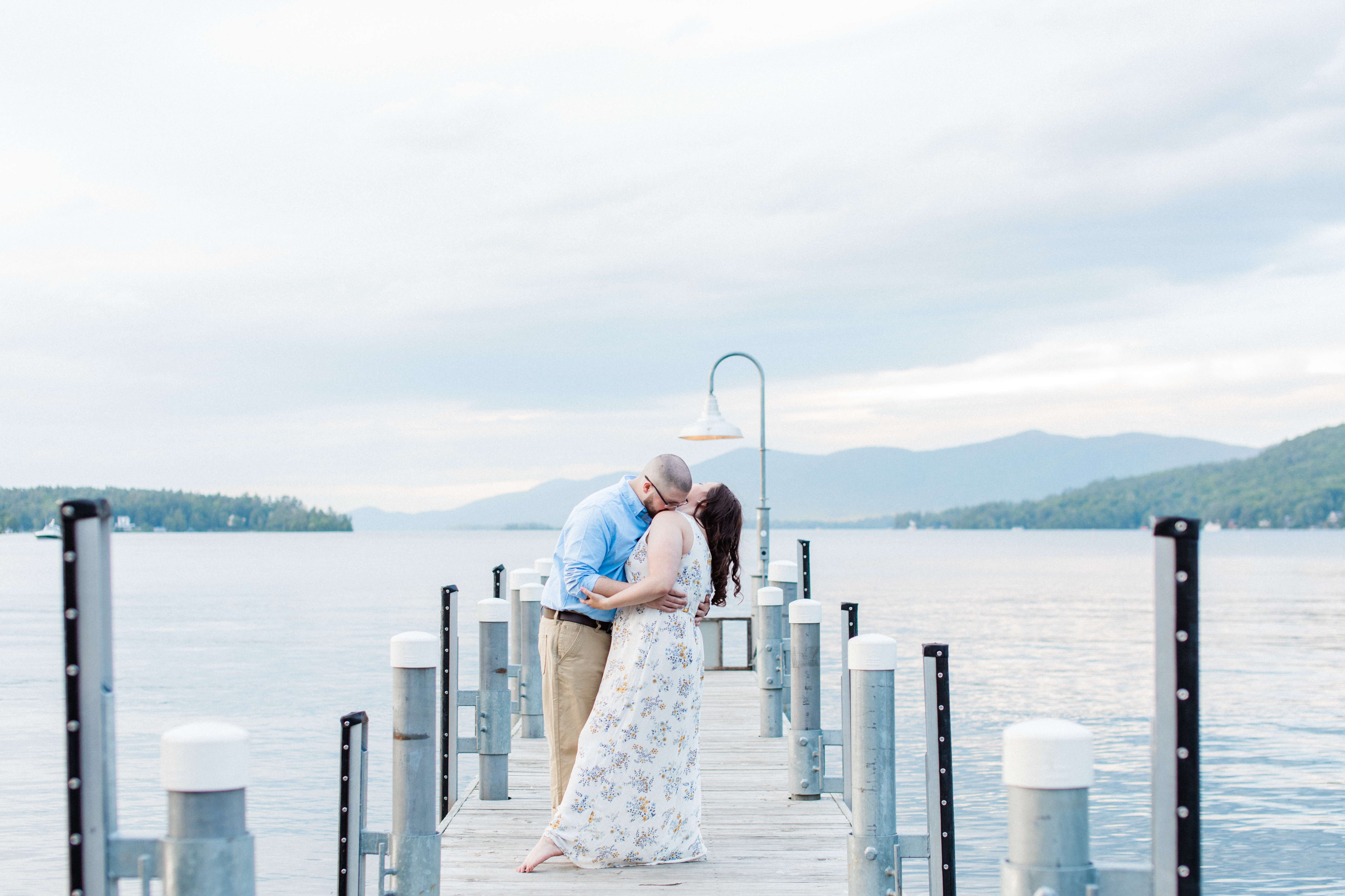 Engaged couple kissing on the dock in Lake George, New York