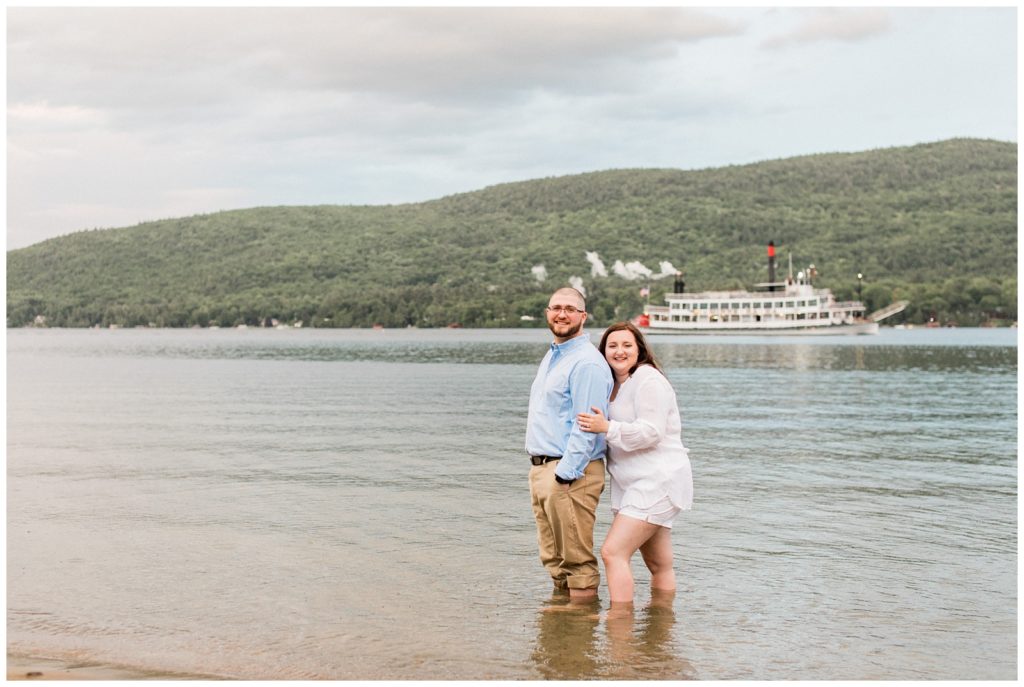 engaged couple wading in the water at Lake George, New York