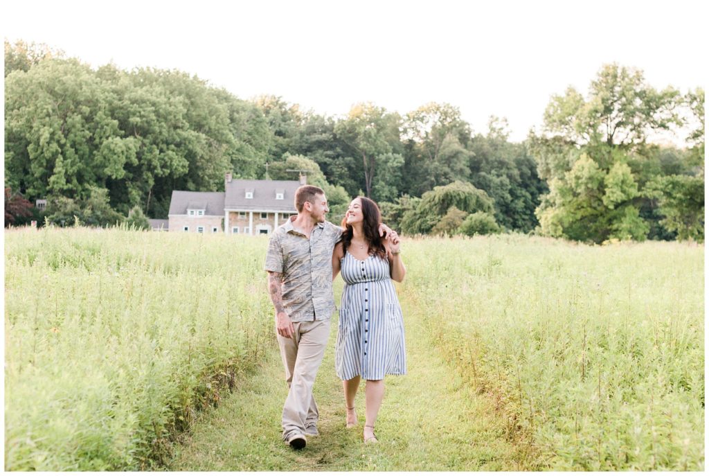 couple walking together in a field in new jersey at kittatinny valley state park
