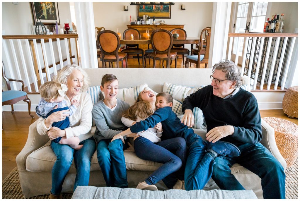 Grandparents with their grandkids cuddling on a couch