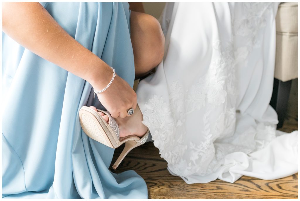 putting the bride's shoes on